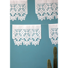 Afbeelding in Gallery-weergave laden, Witte papel picado-slingers tegen een blauwe muur boven cactussen
