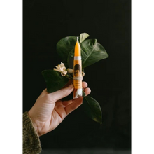 Afbeelding in Gallery-weergave laden, Hand met een oranje rituele kaars Nerolí van Antevasin's Store en een takje met bladeren